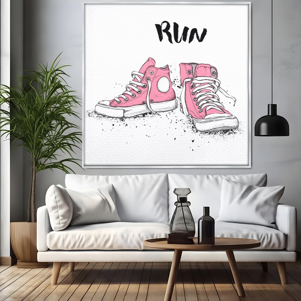 Tablou canvas cu illustratie cu adidasi roz si mesaj, in rama de aluminiu argintiu, pe perete intr-un living